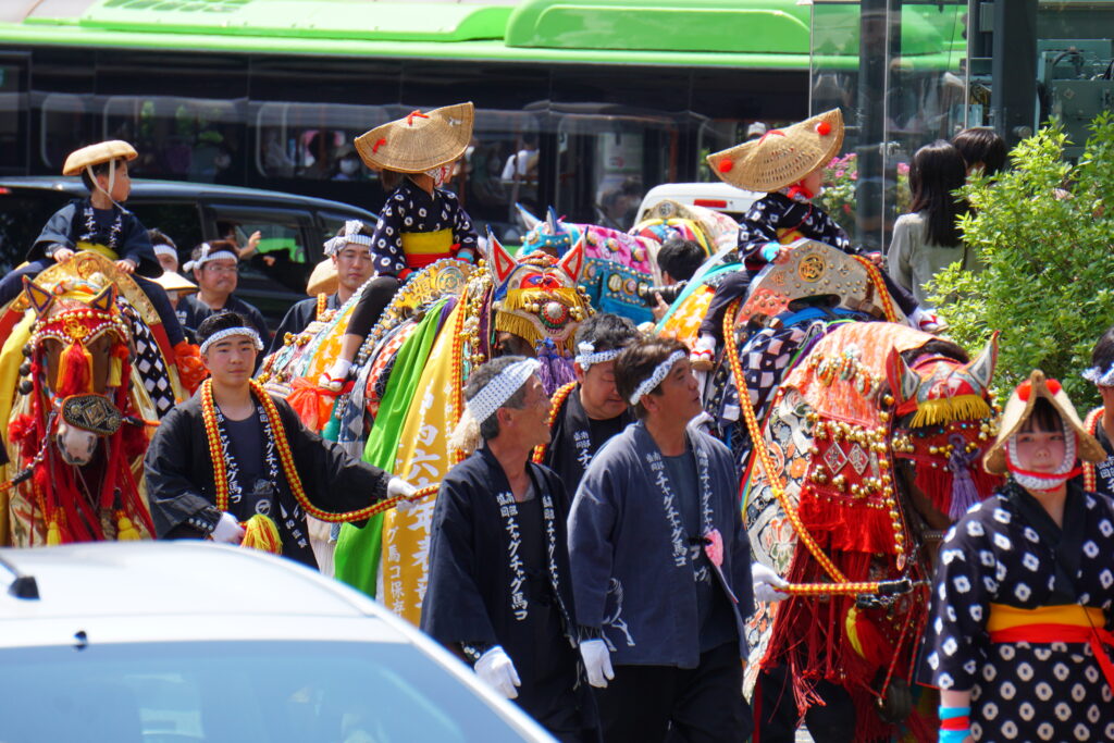 Horses in ornate bell-covered costumes parade during Chagu Chagu Umakko
