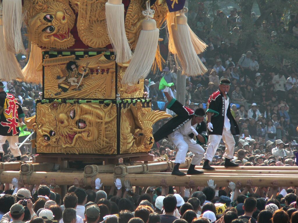 Golden taiko drum float lifted by bearers at Niihama