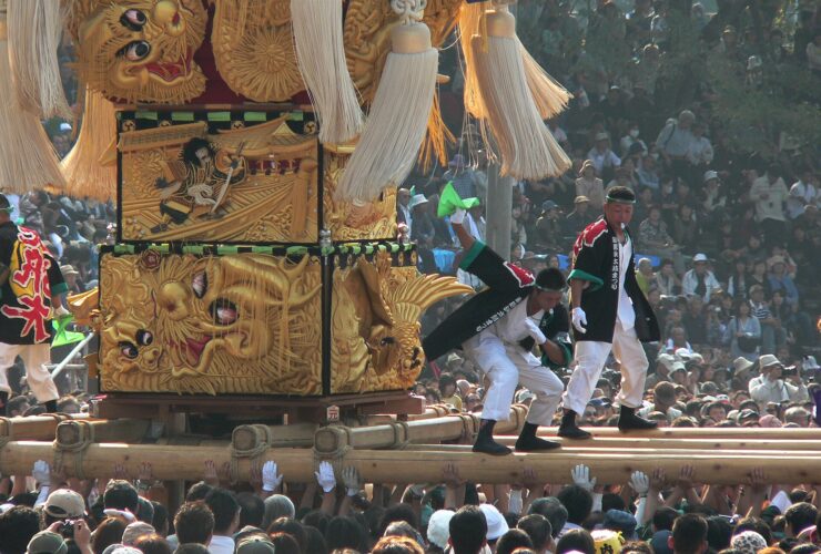 Golden taiko drum float lifted by bearers at Niihama