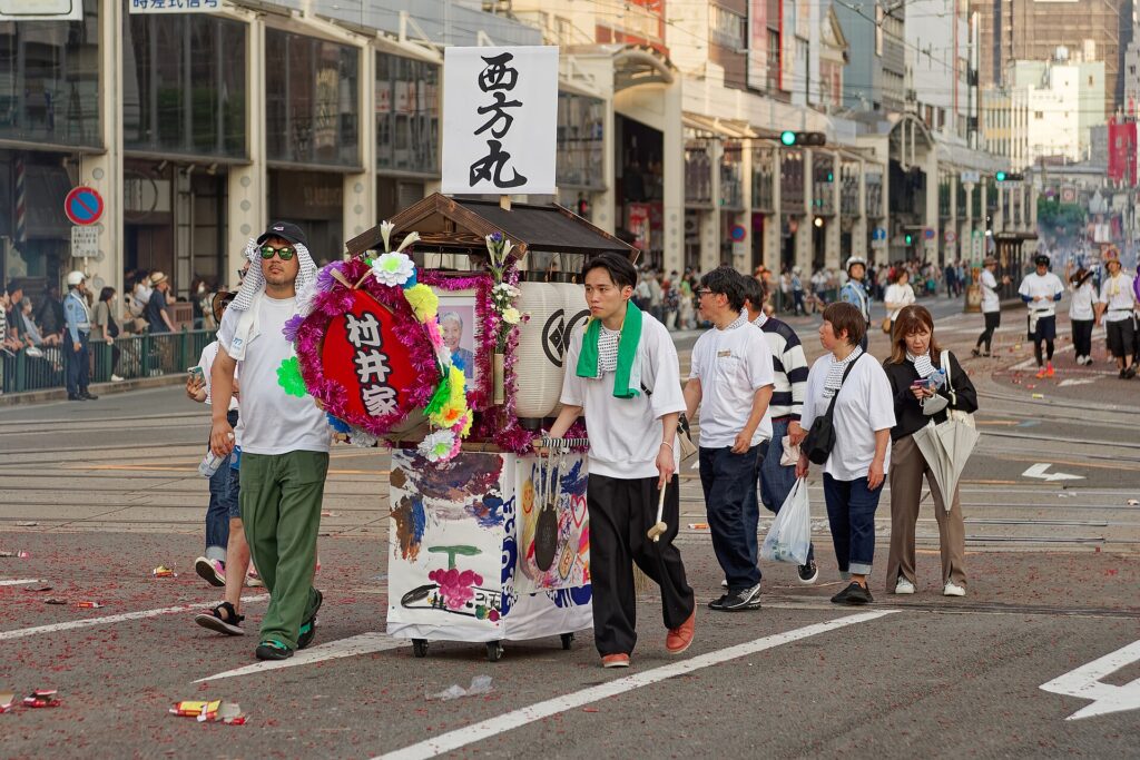 Spirit boats being pulled through central Nagasaki during Shoro Nagashi