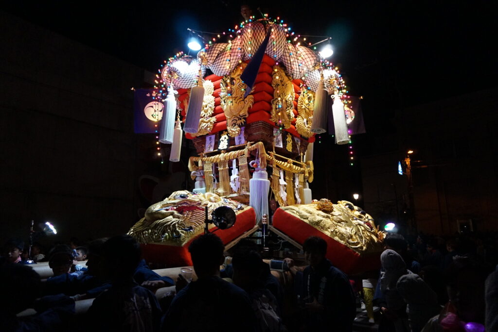 An illuminated chosa drum float carried through the streets at night in Kagawa